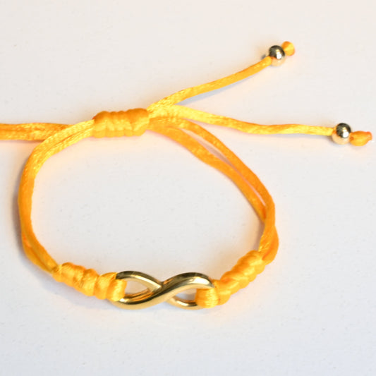 Yellow bracelet with an infinity symbol on a light gray background